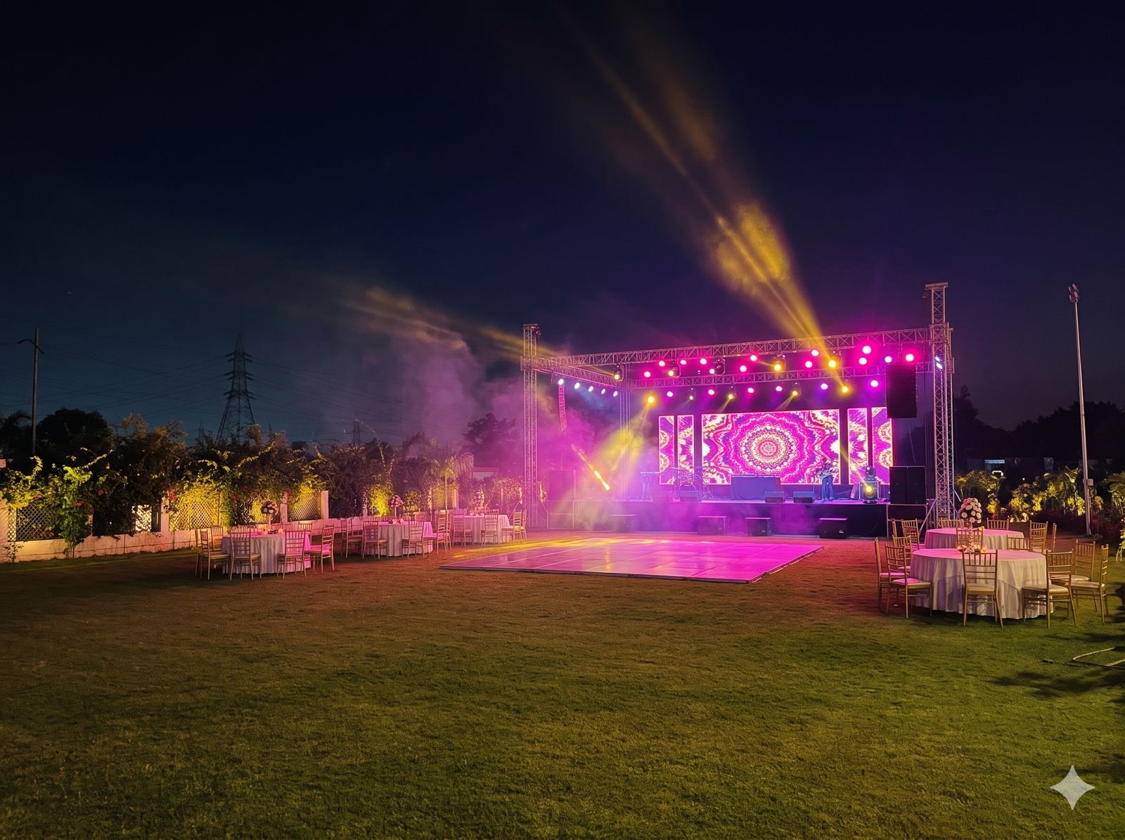 Concert stage with LED wall and beam lights over an open dance floor